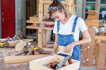 portrait of beautiful asian woman carpenter dealing with handicraft, woman has own business...