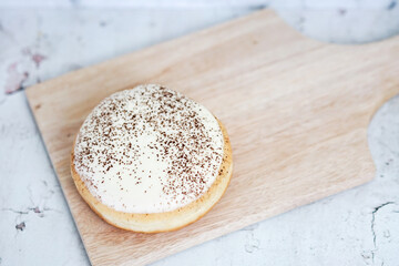 Tiramisu Doughnut Delicious appetizing cake, cream on a white glaze