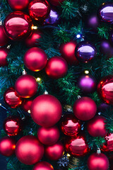 Colorful Christmas balls on a huge Christmas tree. The concept of a new year and Christmas. Vertical photo.