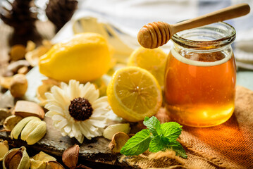 Honey with fresh lemon on wooden table background,  honey dipper
