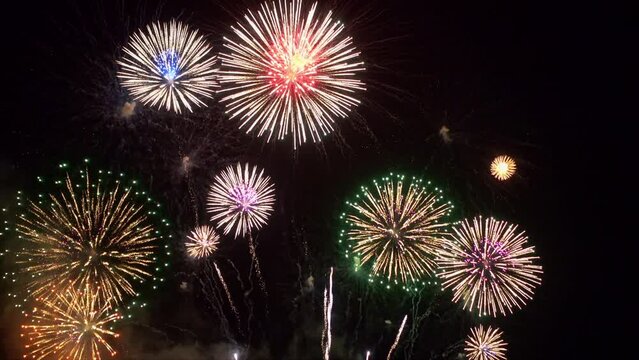 A massive number of fireworks explode in mid-air, filling the sky with shimmering light.