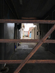 Rusty gate at the entrance to a dark alleyway in central Invercargill, New Zealand.