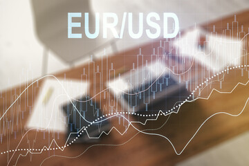 Double exposure of creative EURO USD forex chart hologram and modern desktop with laptop on background. Banking and investing concept