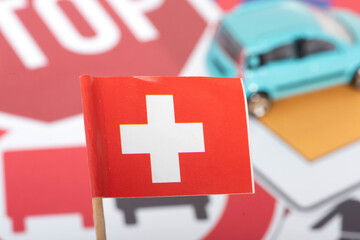 Flagge von der Schweiz, Verkehrsschilder und ein Auto