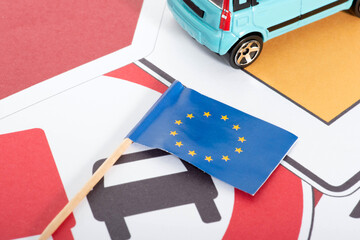 Flagge der Europäischen Union, Verkehrsschilder und ein Auto