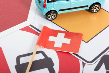Flagge der Schweiz, Verkehrsschilder und ein Auto - obrazy, fototapety, plakaty