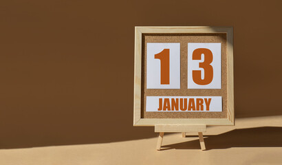 January 13th. Day 13 of month, Calendar date. Cork board, easel in sunlight on desktop. Close-up,...