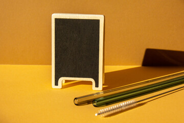 Reusable glass Straws in Glass with water on beige neutral background with label for your text...