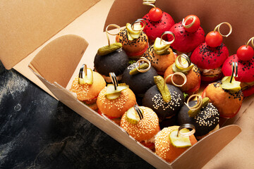 Small burgers on dark background.