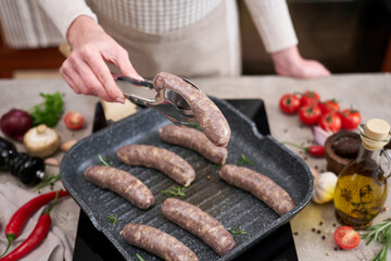 Grilled sausages on a grill frying pan on a domestic kitchen