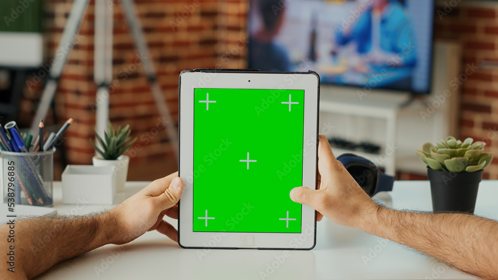 Poster caucasian manager using digital tablet with greenscreen template, vertically holding wireless device