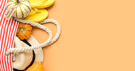 Beach bag with flip-flops, hat and pumpkins on orange background with space for text. Happy Thanksgiving Day