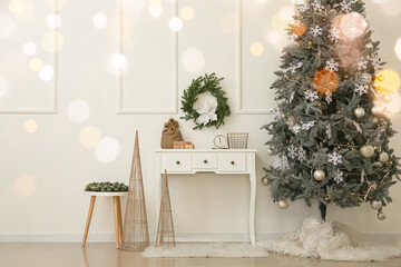 Interior of room with Christmas tree, table and decor near white wall
