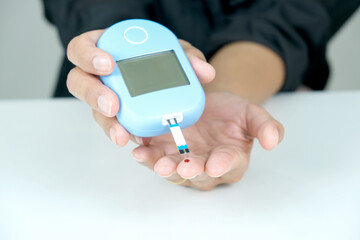 hand of people check diabetes and high blood glucose monitor with digital pressure gauge. Healthcare and Medical concept.