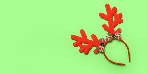 Beautiful Christmas reindeer horns on green background with space for text