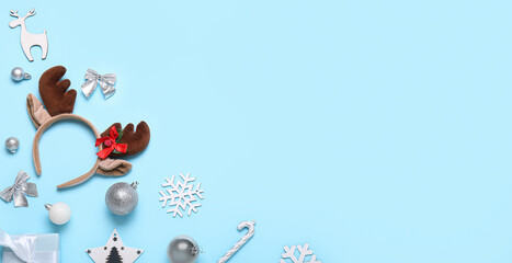 Composition with Christmas reindeer's horns and beautiful decor on light blue background with space for text