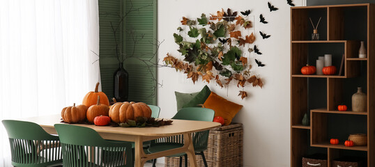 Interior of modern dining room with fresh pumpkins, table, autumn leaves and shelving unit