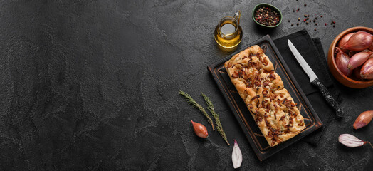 Composition with tasty Italian focaccia and ingredients on dark background with space for text