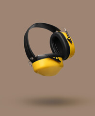 Modern hearing protectors on beige background