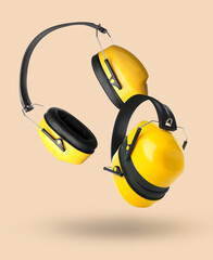 Modern hearing protectors on beige background