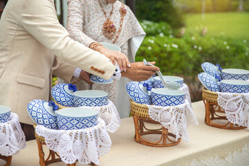 The bride and groom's hand Filling Rice in thailand wedding.wedding ceremony Temple of love for the newlyweds.