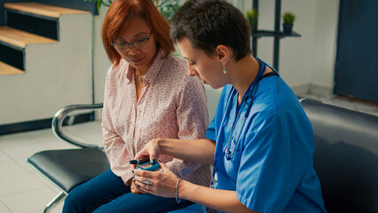 Nurse measuring insulin and glucose level with glucometer, doing cehckup examination with diabetic...