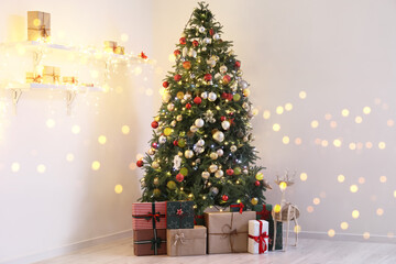 Christmas tree, gift boxes and reindeer near light wall