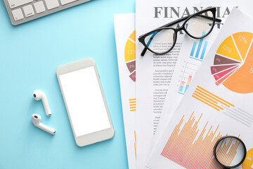 Business charts, gadgets and stationery on blue background