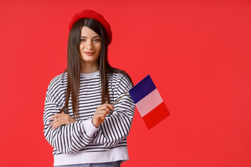 Beautiful young woman with flag of France on red background