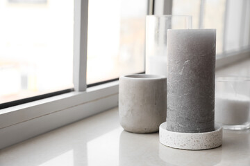 Different candles on white windowsill