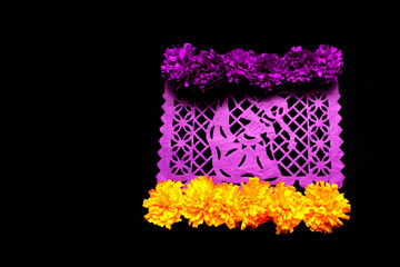 Traditional colored Papel Picado and cempasuchil flowers decorative objects of the altar of the Day of the Dead part of the culture of Mexico with black background for phrases, post and invitations