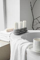 Fototapeta na wymiar Holder with candles on modern bathtub