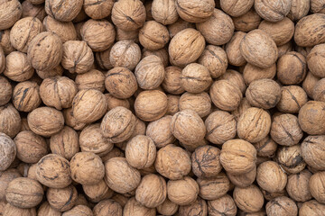 Pile of raw walnuts on the stock texture, top view.