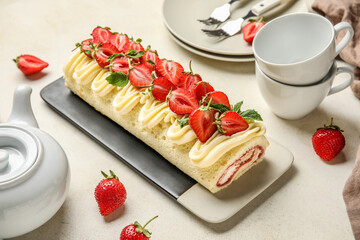 Plate of tasty roll cake with fresh strawberry on light background