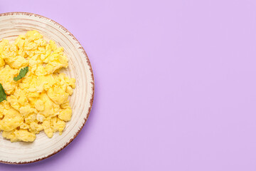 Plate of tasty scrambled eggs on lilac background