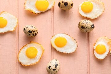 Fried and raw quail eggs on color wooden background, closeup