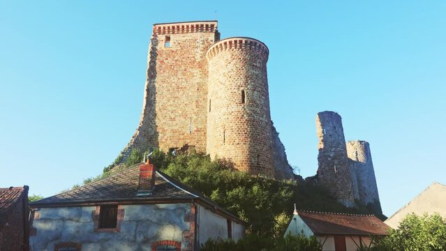 Remains of stone walls and tower of ancient fortified chateau on hilltop in French village of Herisson on sunny summer day, Allier department . High quality 4k footage