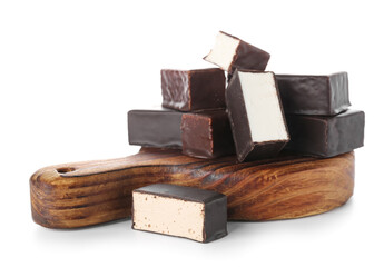 Wooden board with tasty bird's milk candies on white background
