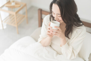 朝、温かい飲み物を飲む女性
