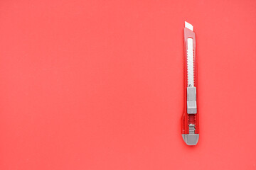 Utility knife on red background