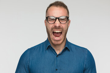 casual man is screaming and wearing a blue shirt
