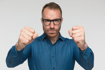 young casual man is showing his fists