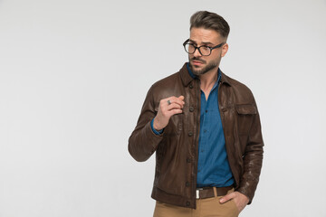 cool young man with brown leather jacket looking to side