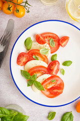 Plate of delicious caprese salad on light background, closeup