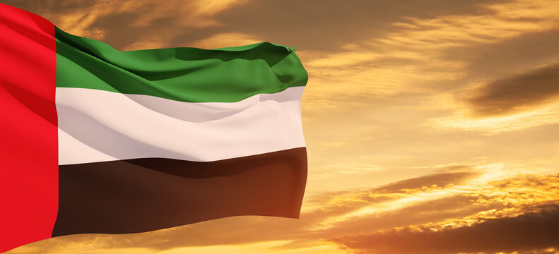 Flag of United Arab Emirates on background of sunset sky. UAE celebration. National day, Flag day, Commemoration day, Martyrs day. Banner with place for text.