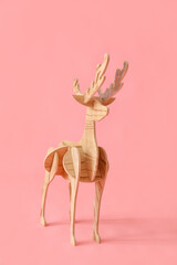 Decorative wooden reindeer on pink background