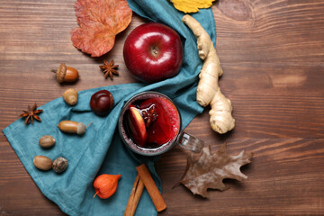Composition with cup of aromatic mulled wine on wooden background
