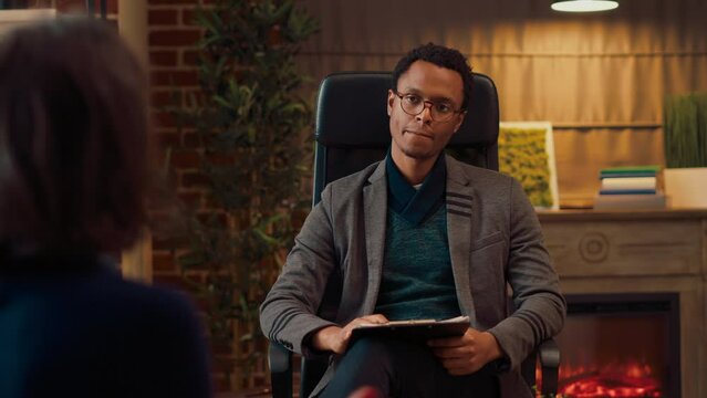 African american counselor listening to couple at therapy session, trying to solve marriage problems. Doing psychotherapy appointment with married people, giving counseling help.