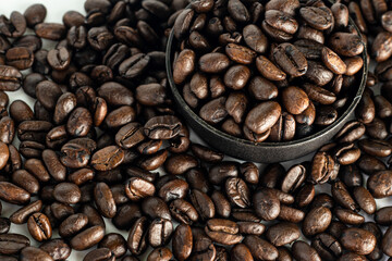 Coffee Beans on white background. close up. Coffee grounds. Freshly roasted coffee beans. Image of a drink made from granules, derived from coffee plant. Copy space for text.