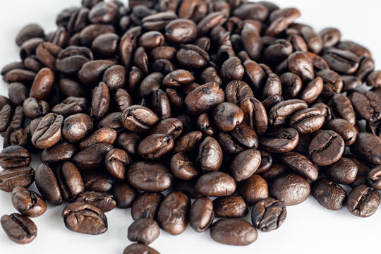 Coffee Beans on white background. Coffee grounds. Freshly roasted coffee beans. Image of a drink made from granules, derived from coffee plant. Copy space for text.